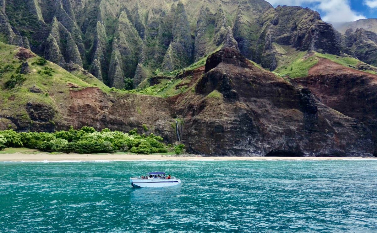 a small boat in a body of water with a mountain in the background