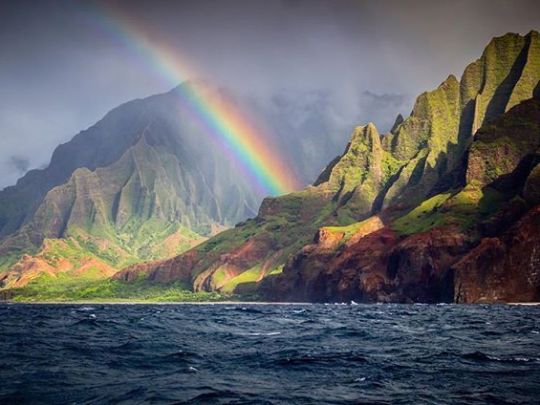 a large body of water with a mountain in the background