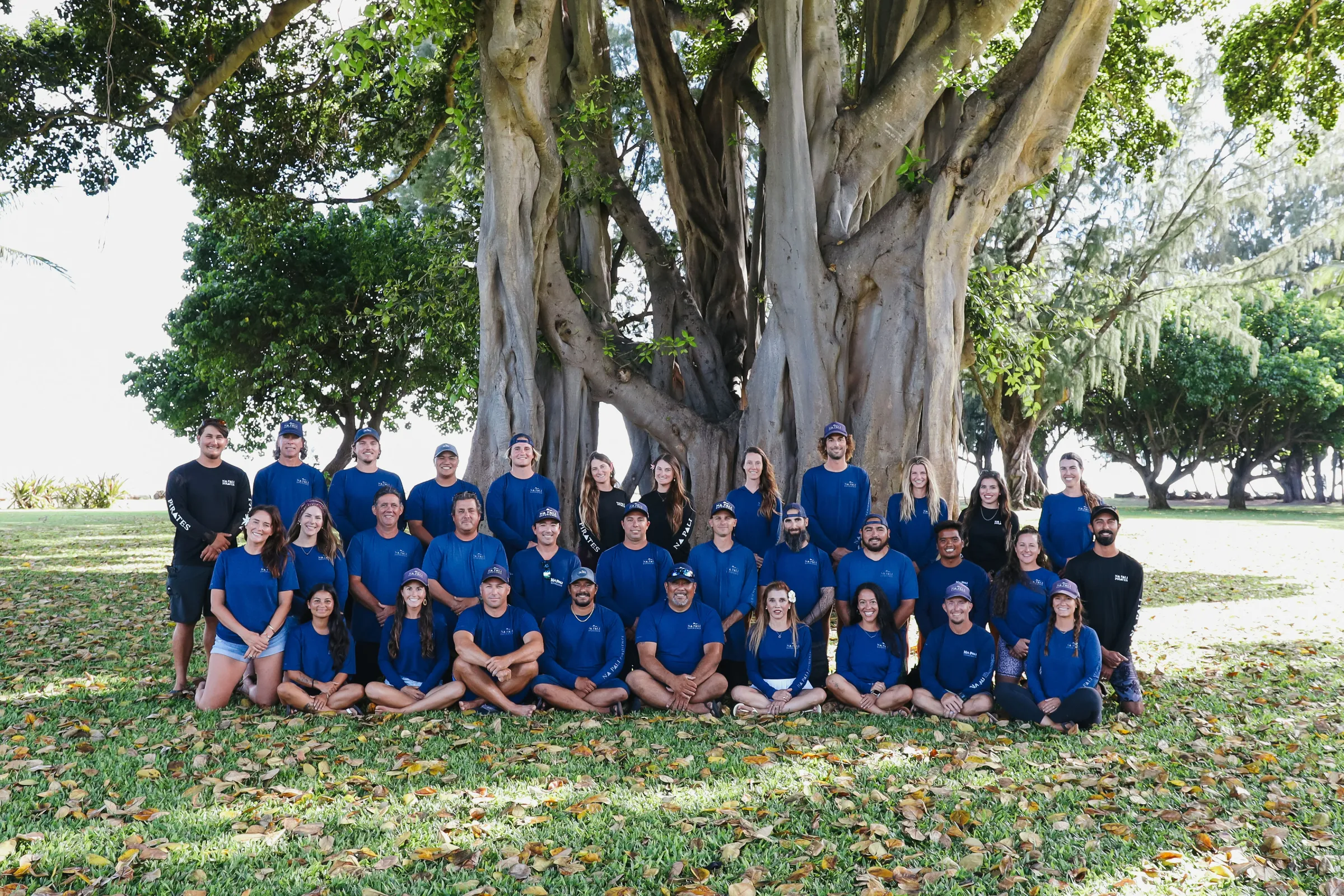 Team2025 a group of people standing next to a tree