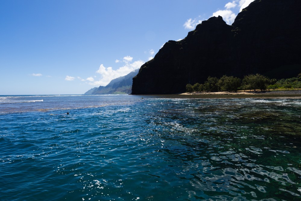 Ocean view with rugged coastline and clear blue sky.